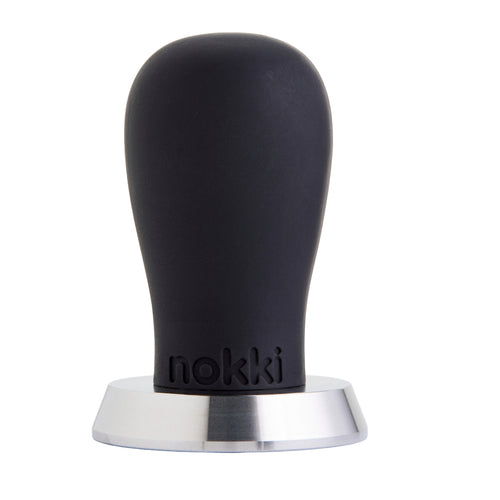 A Nokki 51mm coffee tamper with a matte black silicone handle and a machined 316 stainless steel base, shown on a solid white background.